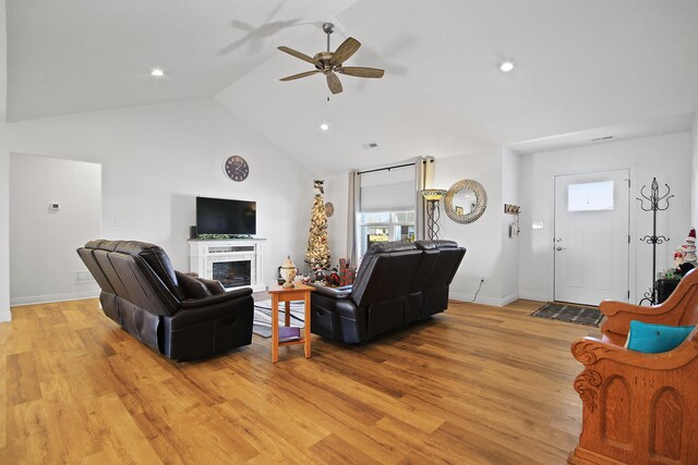 living room with ceiling fan, light hardwood / wood-style floors, and high vaulted ceiling