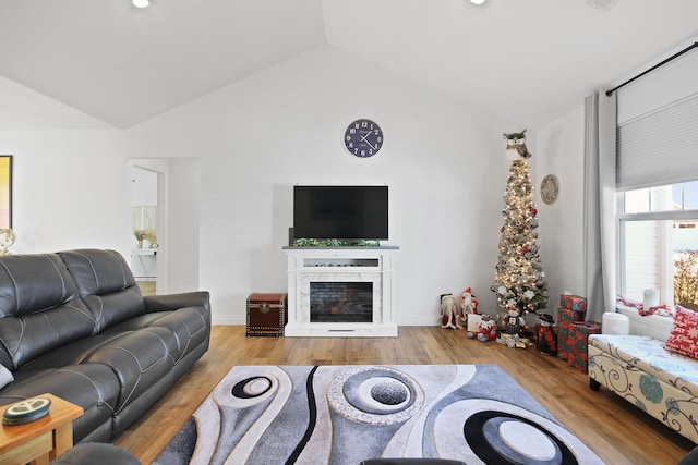 living room with light hardwood / wood-style floors and vaulted ceiling