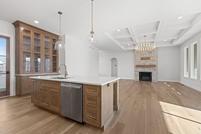 kitchen with dishwasher, coffered ceiling, sink, an island with sink, and light hardwood / wood-style floors