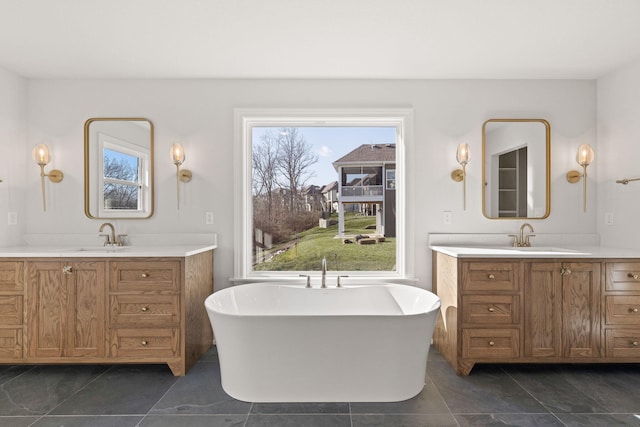 bathroom with a tub to relax in, tile patterned floors, and vanity