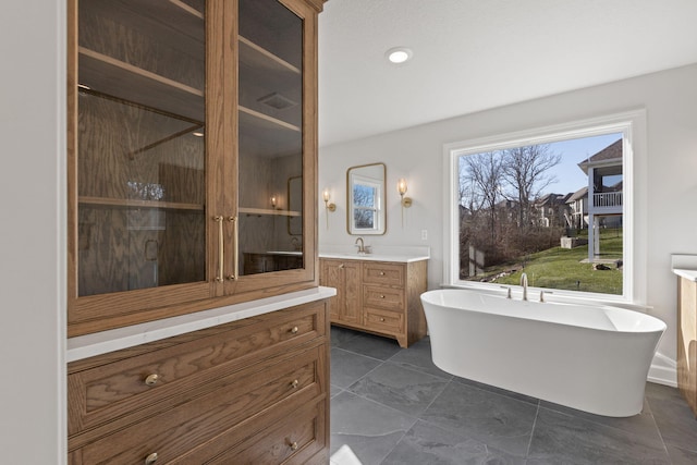 bathroom with a tub and vanity