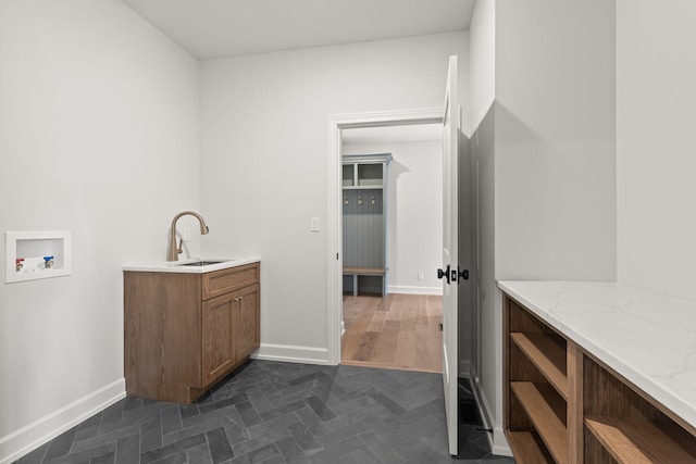 clothes washing area with hookup for a washing machine, cabinets, sink, and dark wood-type flooring