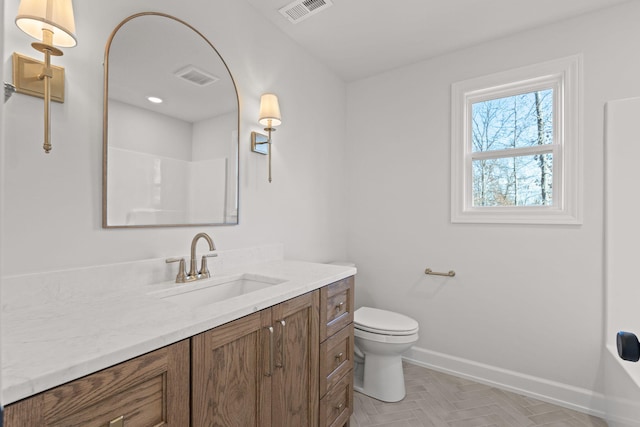 bathroom with a shower, vanity, toilet, and parquet floors