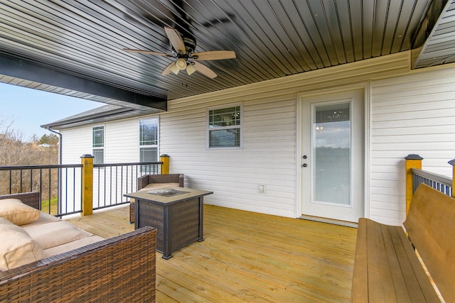 wooden deck with an outdoor living space with a fire pit and ceiling fan