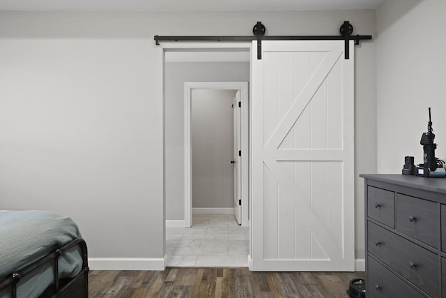 bedroom featuring a barn door and wood-type flooring