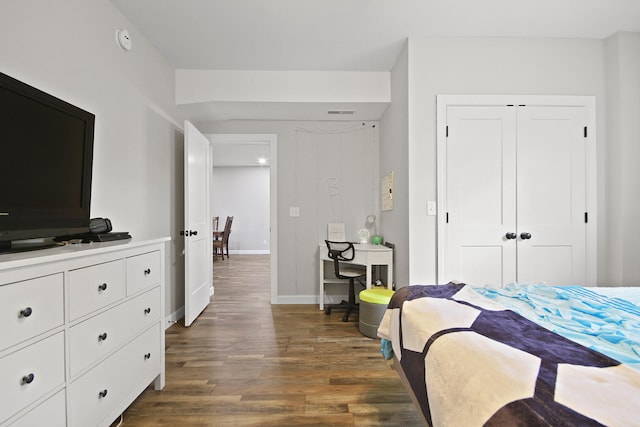 bedroom with a closet and dark wood-type flooring