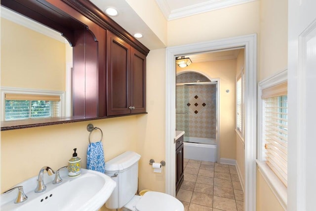 full bathroom with sink, tiled shower / bath combo, tile patterned flooring, crown molding, and toilet