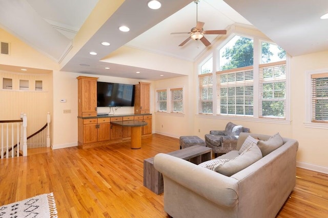 living room with ornamental molding, light wood-type flooring, ceiling fan, and lofted ceiling