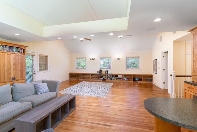 living room featuring plenty of natural light, light wood-type flooring, and vaulted ceiling