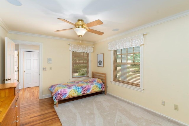 bedroom featuring light hardwood / wood-style floors, ceiling fan, and ornamental molding