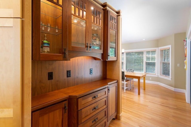 513 Rockhill Rd, Columbia, MO 65201 - kitchen with light wood-style flooring, brown cabinetry, and glass insert cabinets