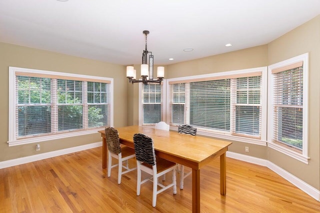 dining area with light hardwood / wood-style flooring and a chandelier