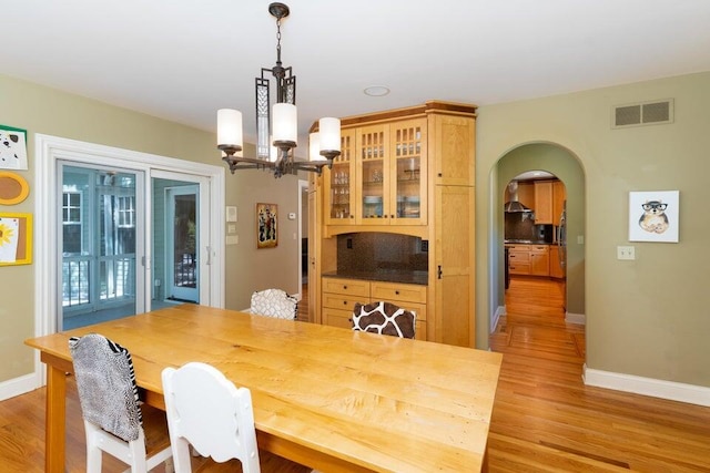 513 Rockhill Rd, Columbia, MO 65201 - dining area featuring a chandelier, light wood-type flooring, and arched walkways