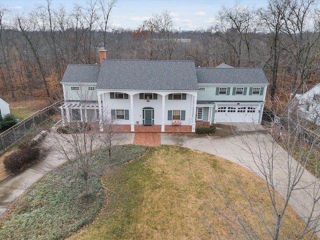 view of front of home with a porch, a front yard, and a garage