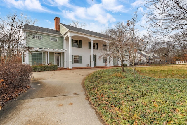 neoclassical home featuring a front yard