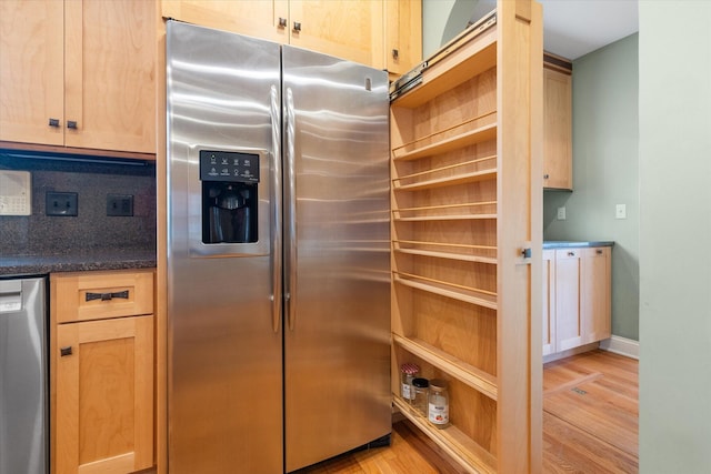 kitchen featuring light brown cabinetry, stainless steel appliances, and light hardwood / wood-style flooring