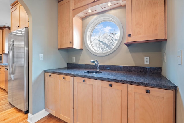 kitchen featuring light brown cabinets, light hardwood / wood-style floors, sink, and appliances with stainless steel finishes