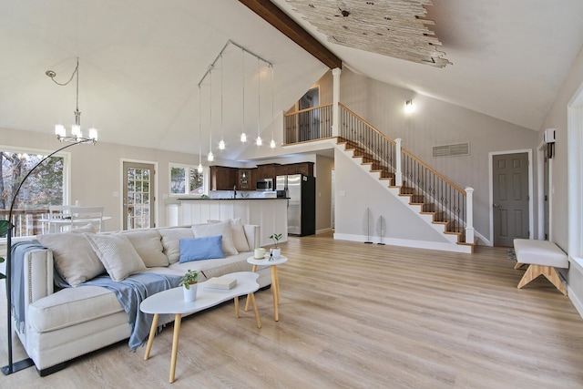 living room featuring a chandelier, beam ceiling, light wood-type flooring, and high vaulted ceiling