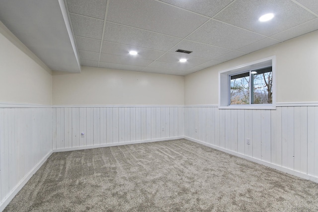 carpeted spare room with a paneled ceiling