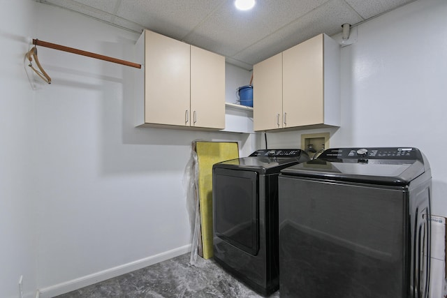 laundry room featuring washer and clothes dryer and cabinets