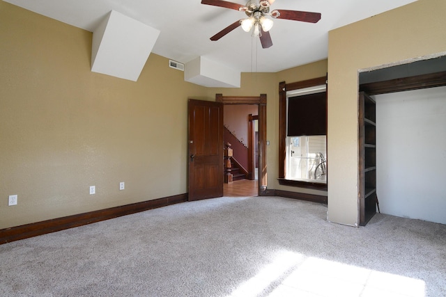 unfurnished bedroom featuring light carpet, a closet, and ceiling fan