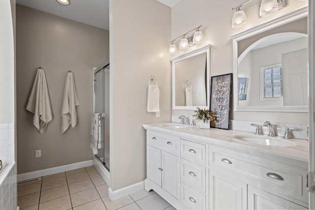 bathroom featuring a stall shower, tile patterned flooring, and a sink