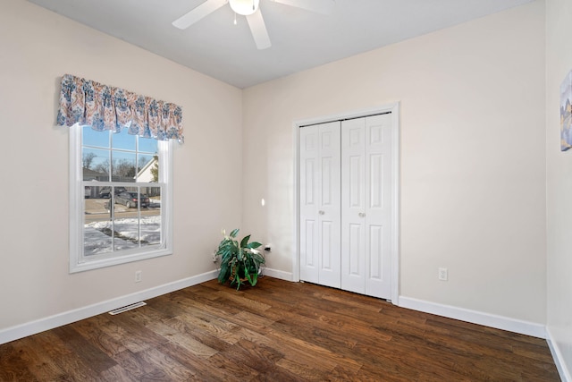 unfurnished bedroom featuring a closet, wood finished floors, visible vents, and baseboards