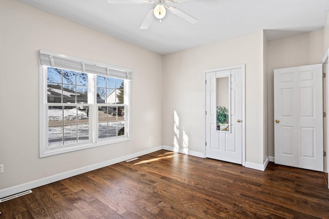 entrance foyer with dark wood-style floors, ceiling fan, visible vents, and baseboards