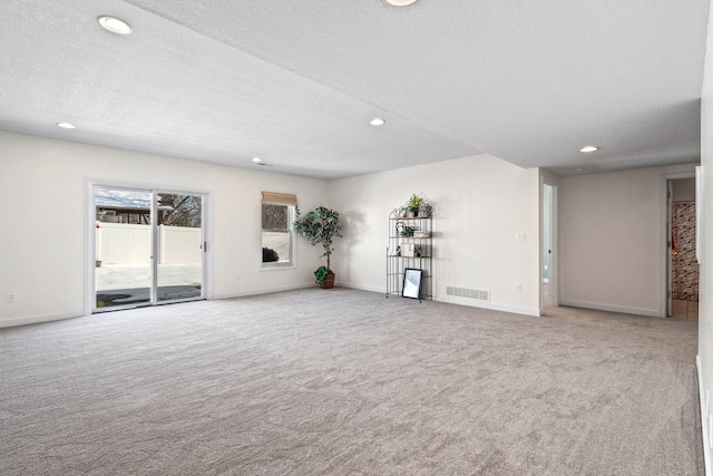 unfurnished living room with baseboards, visible vents, a textured ceiling, carpet flooring, and recessed lighting