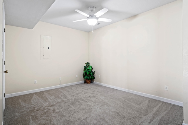 unfurnished room with carpet floors, ceiling fan, electric panel, and baseboards