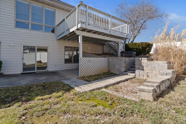 back of property featuring a deck, a patio area, and stairway