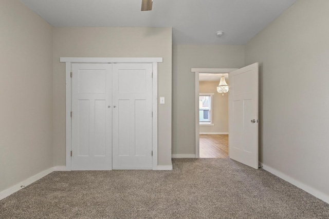 unfurnished bedroom with ceiling fan, carpet floors, and a closet