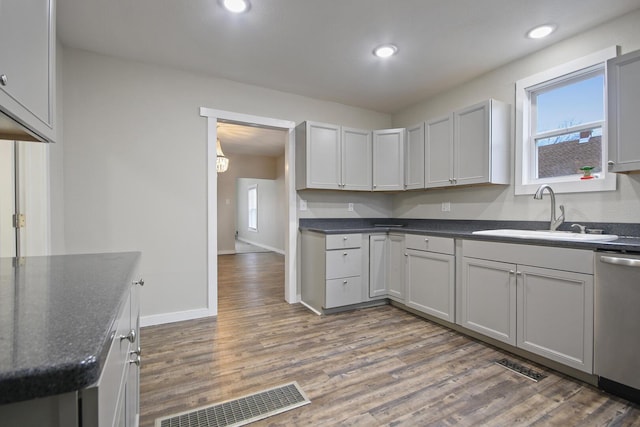 kitchen with hardwood / wood-style floors, sink, and stainless steel dishwasher