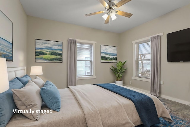 bedroom featuring multiple windows, ceiling fan, and carpet