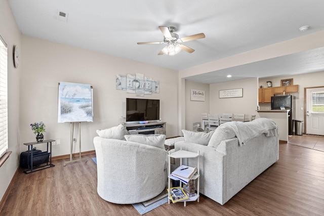 living room featuring ceiling fan, plenty of natural light, and light hardwood / wood-style flooring