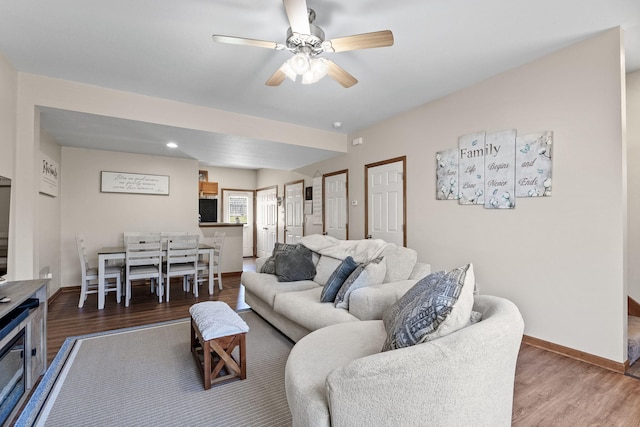 living room with ceiling fan and dark hardwood / wood-style flooring