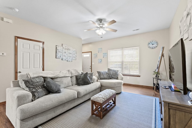 living room with wood-type flooring and ceiling fan