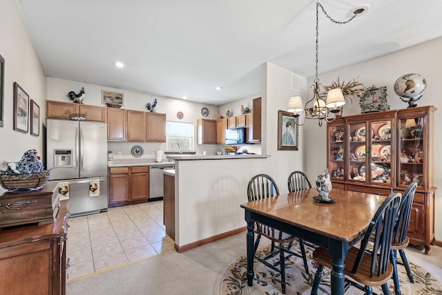 tiled dining room with a notable chandelier