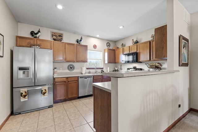 kitchen with kitchen peninsula, sink, light tile patterned flooring, and stainless steel appliances