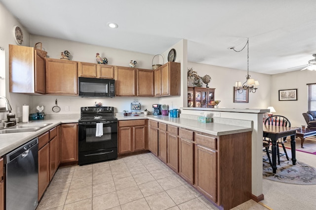 kitchen with black appliances, ceiling fan with notable chandelier, sink, decorative light fixtures, and kitchen peninsula