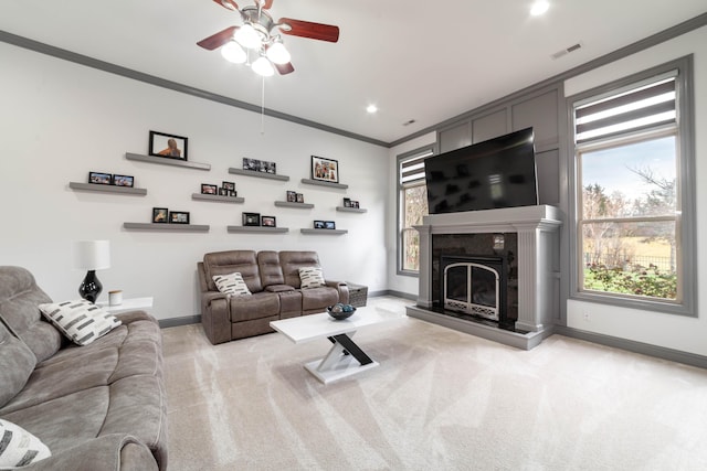 carpeted living room featuring ceiling fan and ornamental molding