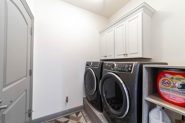 laundry room with separate washer and dryer and cabinets