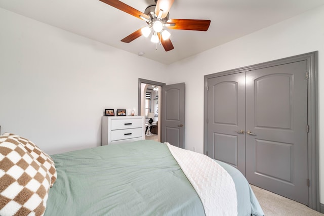 carpeted bedroom featuring ceiling fan and a closet