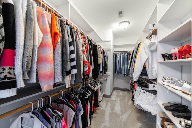 spacious closet featuring light colored carpet