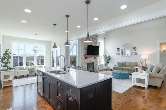 kitchen featuring dishwasher, dark wood-type flooring, open floor plan, and a sink