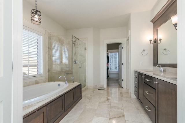 full bathroom featuring vanity, baseboards, a bath, a stall shower, and a walk in closet