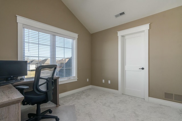 office space with light colored carpet, visible vents, and vaulted ceiling