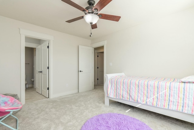 carpeted bedroom with ceiling fan, baseboards, and ensuite bathroom