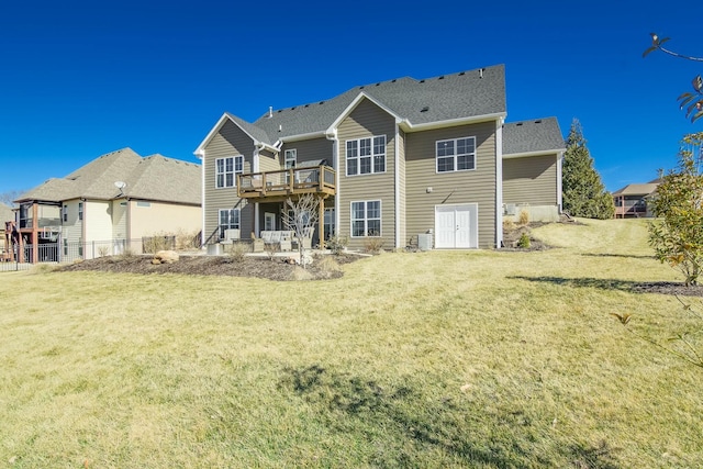 rear view of property with a lawn and a wooden deck