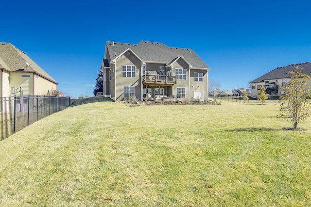 back of property with fence, a lawn, and a wooden deck